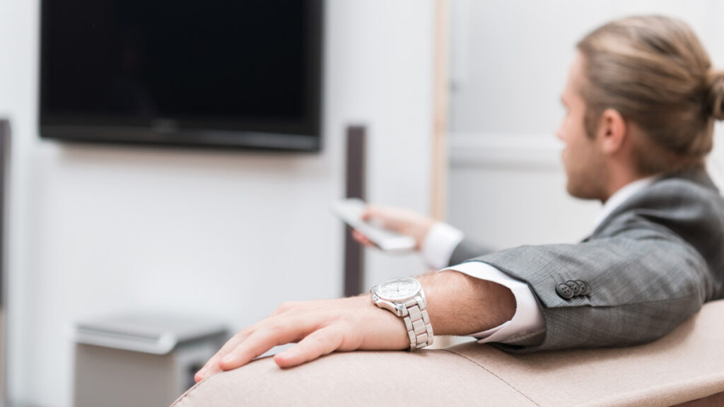 Businessman sitting at home and watching TV