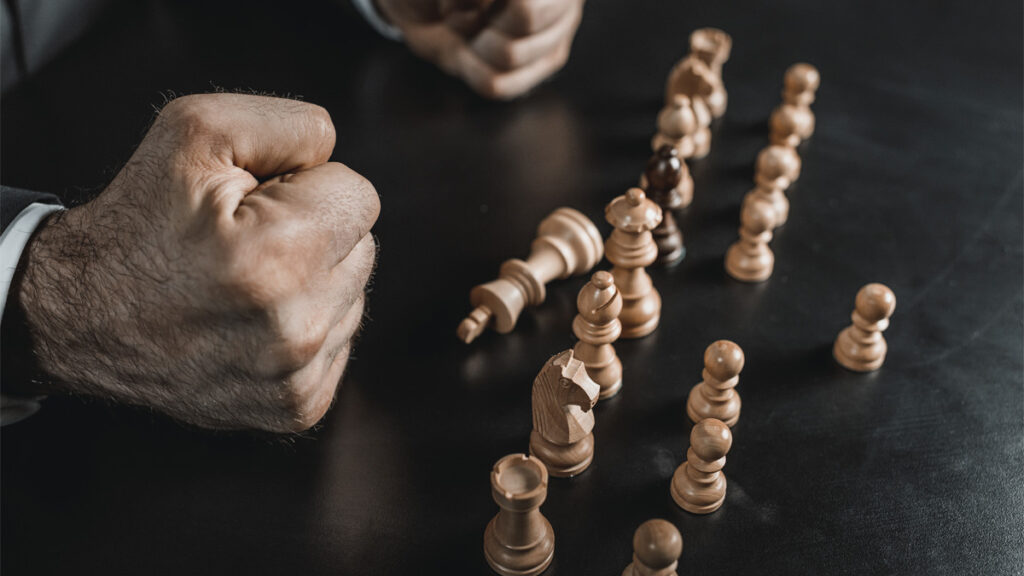 Partial view of businessman with chess figures on table