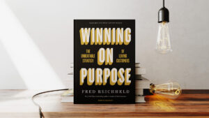 Winning on purpose book on a table with a stack of books and two lights