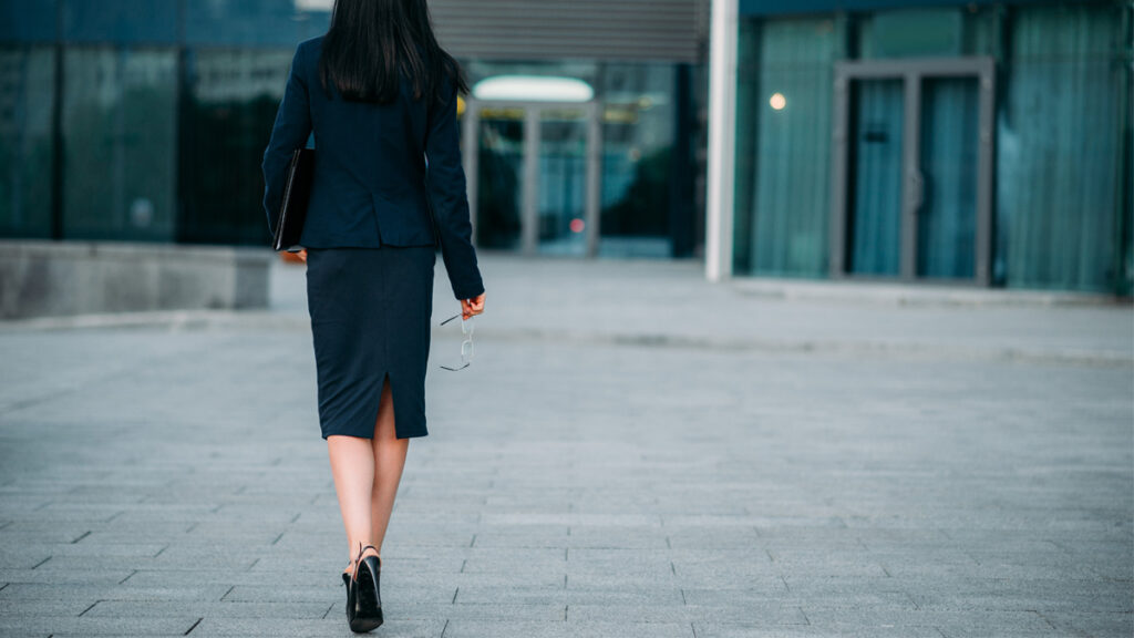Business woman with laptop in hands, back view