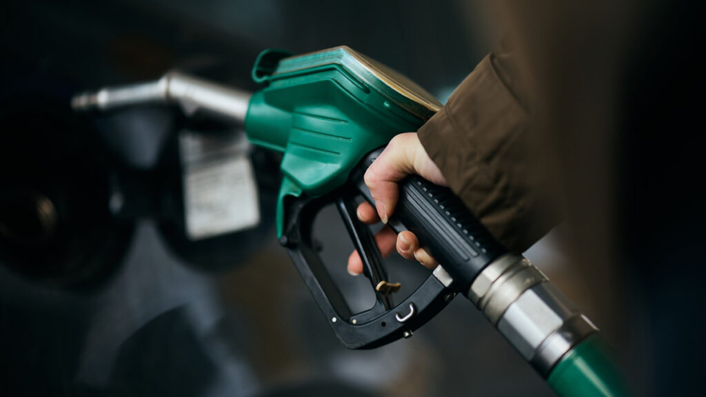 Close-up of woman pouring fuel in gas tank of her car