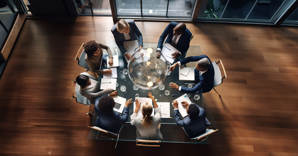 Eight people sitting around a table in a meeting